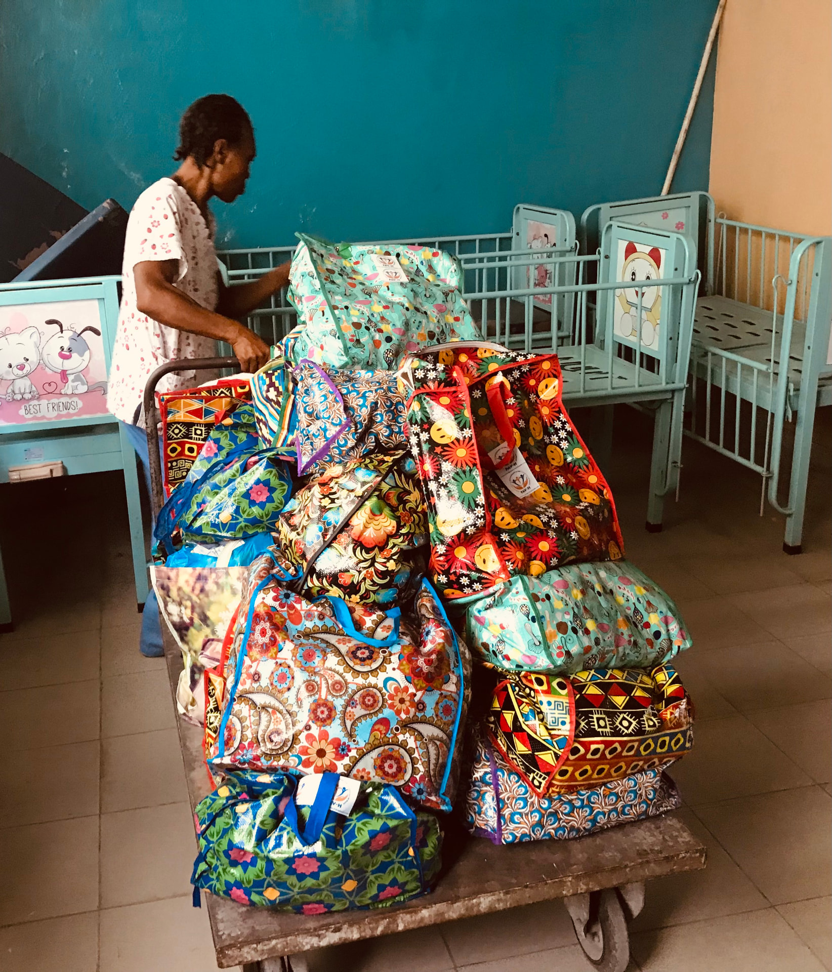 Chariot rempli de sacs colorés dans une salle d'hôpital avec des lits d'enfants