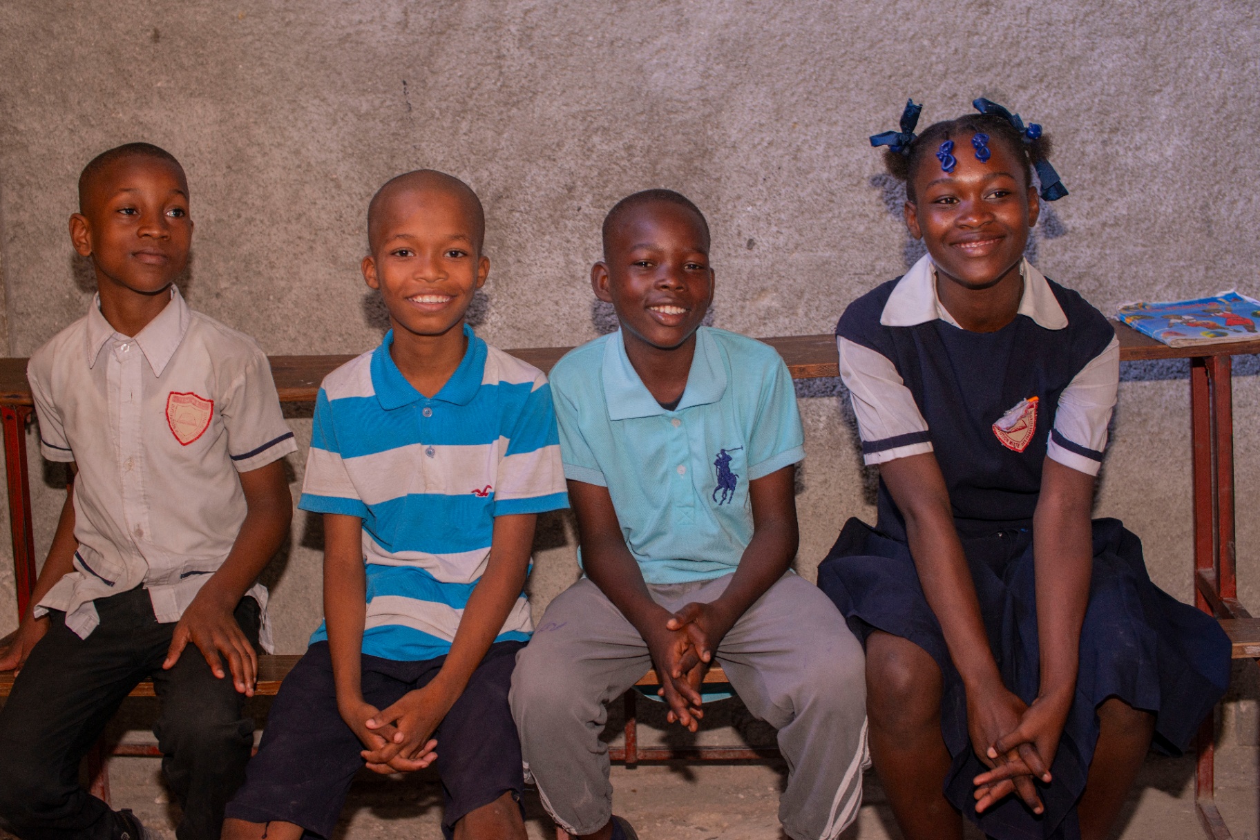 Four smiling children in their school uniforms