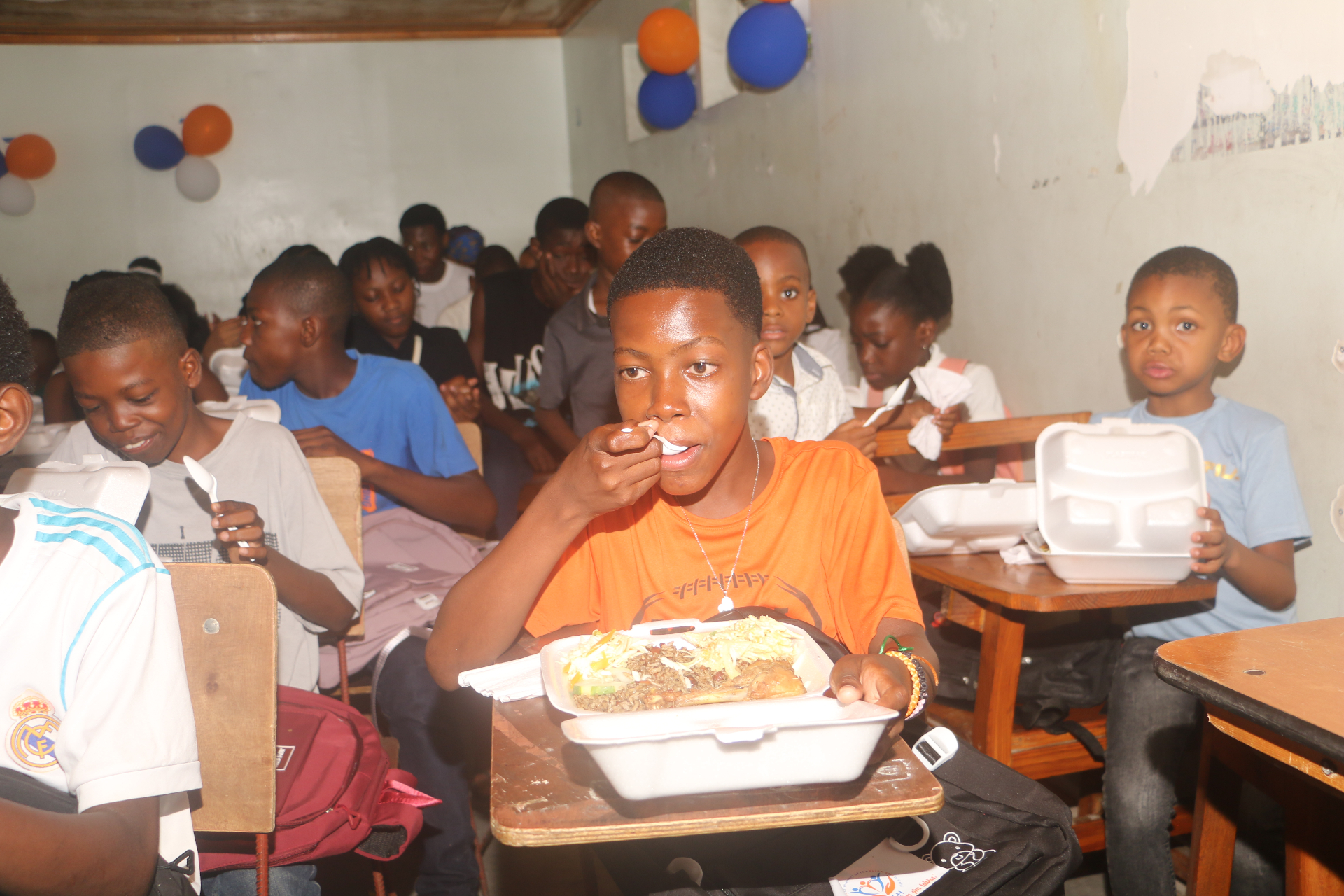 Jeunes haïtiens partageant un repas lors d'une action PAV-H