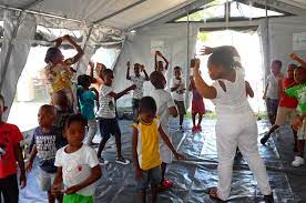 Haitian children dancing and singing during a PAV-H activity