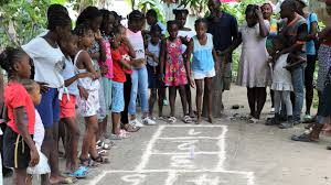 Group of children and teenagers playing hopscotch in a Haitian village